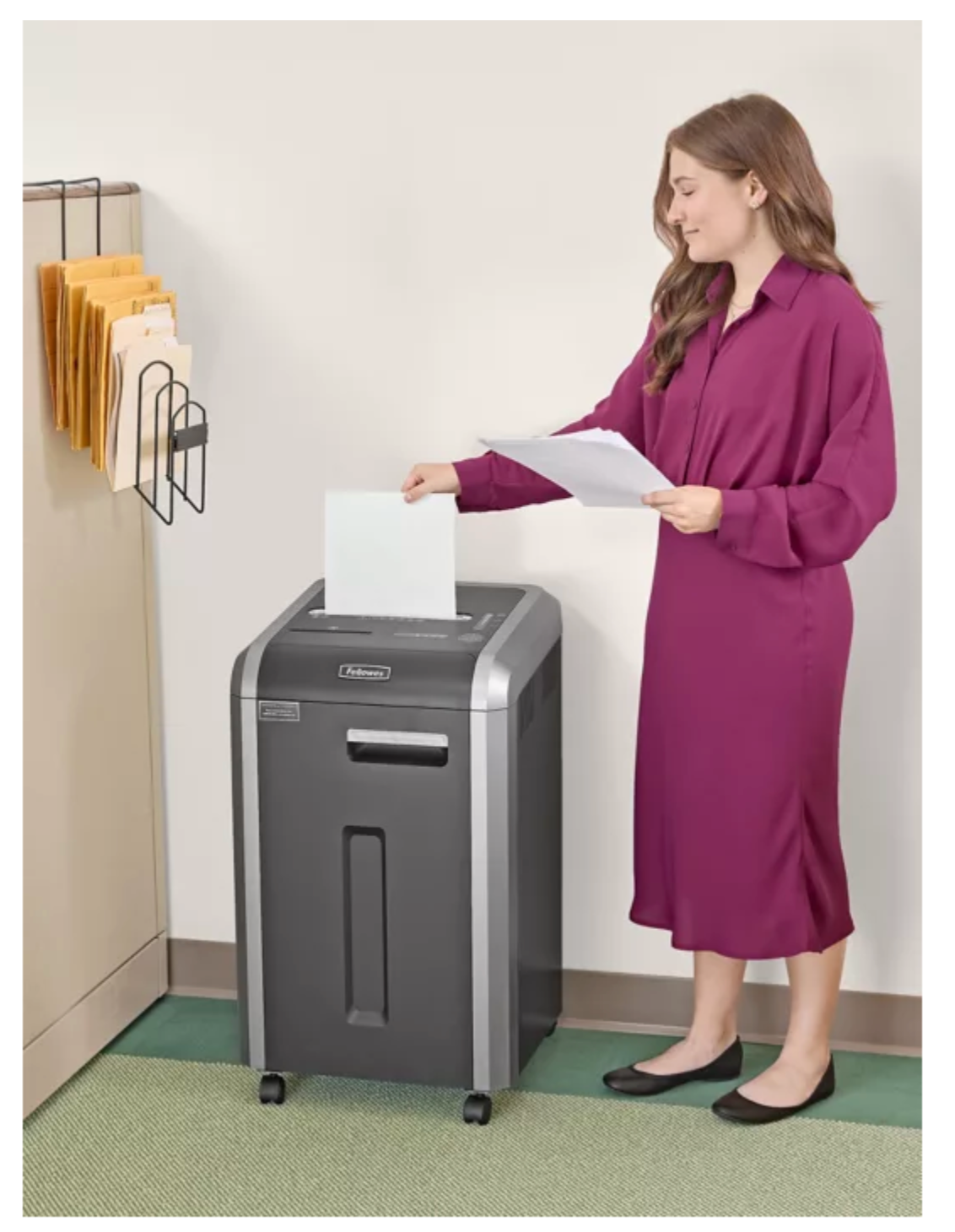 Woman using a paper shredder in an office setting
